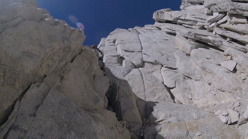 Andrew Kiselev is disappearing in the chimney leading up to a technical terrain on mt. Mills that he will free solo.